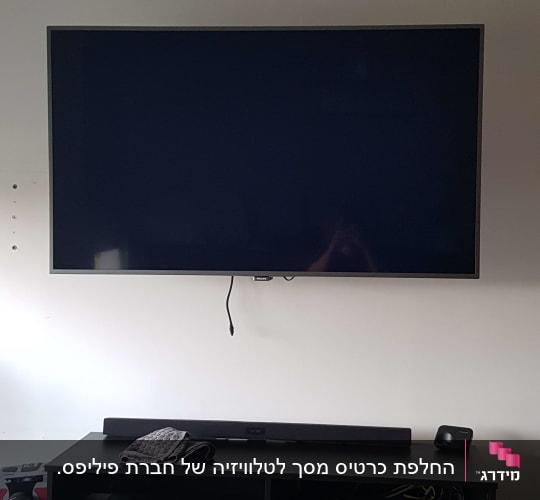 טלוויזיה תלויה על הקיר עם סאונד בר וממיר